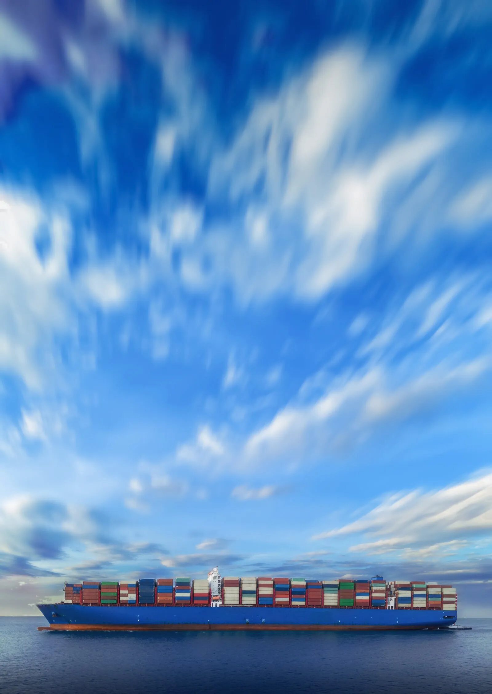 Container vessel at sea under a wide sky